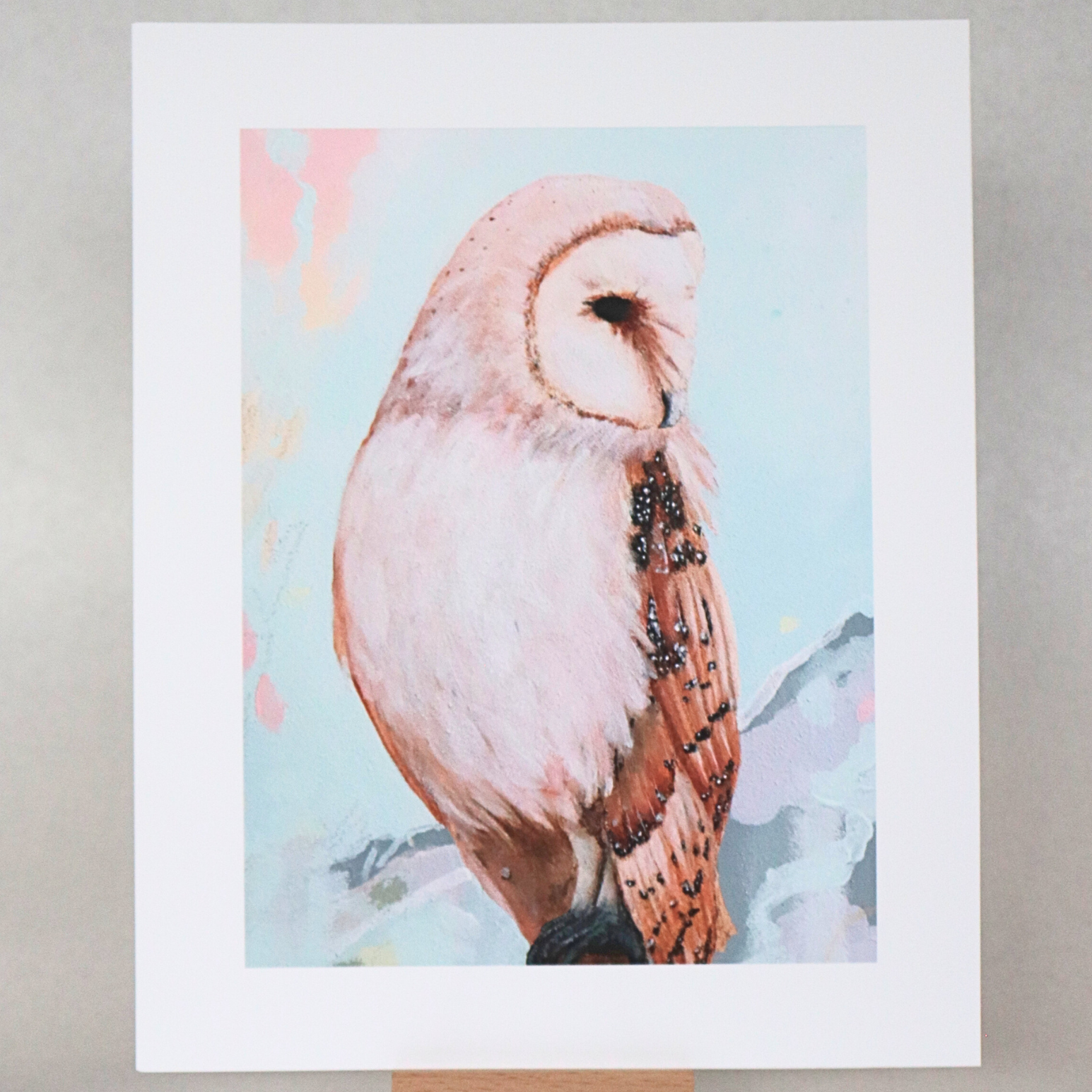 Unframed artwork of an owl on a stand against a gray background